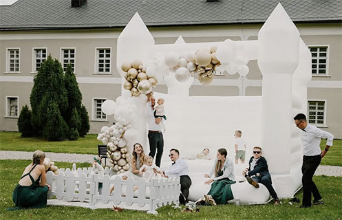 Skákací hrad s balónkovou výzdobou pro dětskou oslavu na zahradě.